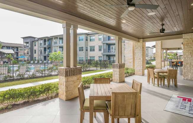 A patio with a table and chairs overlooking a parking lot.