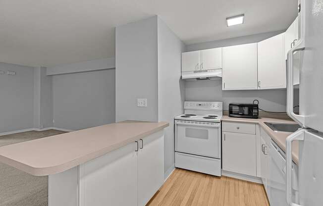 A kitchen with white appliances and cabinets