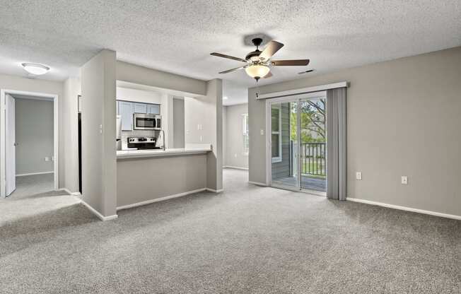 an empty living room with a ceiling fan and a kitchen at Trails at Short Pump Apartments, Richmond, 23233