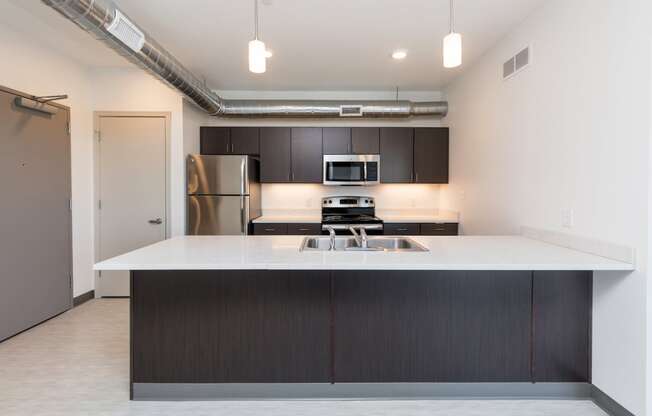 Modern open-concept kitchen and living area with stainless steel appliances.