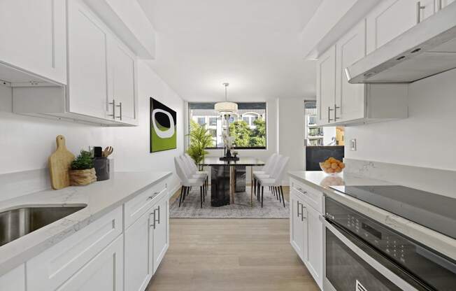 an open kitchen with white cabinets and a dining room with a table