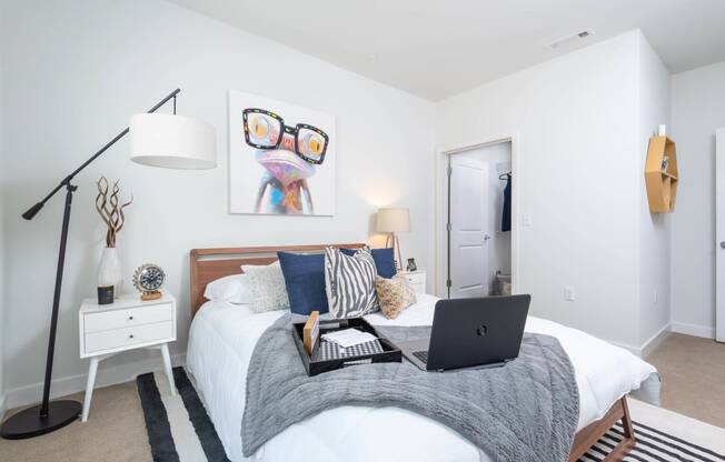 a bedroom with a bed with a laptop on it