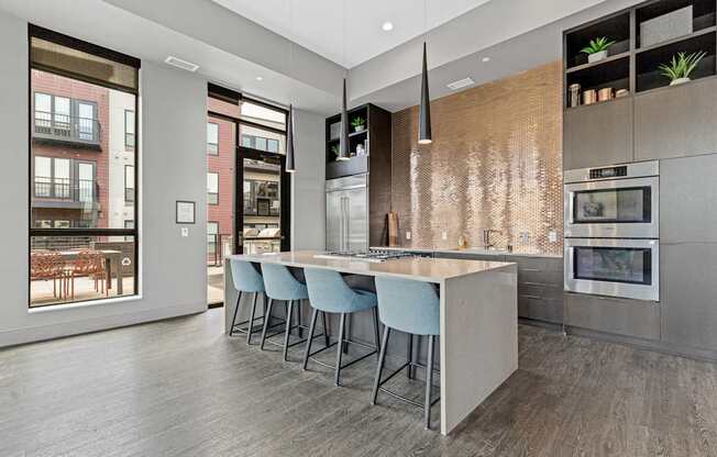 A modern kitchen with a long island and stools.