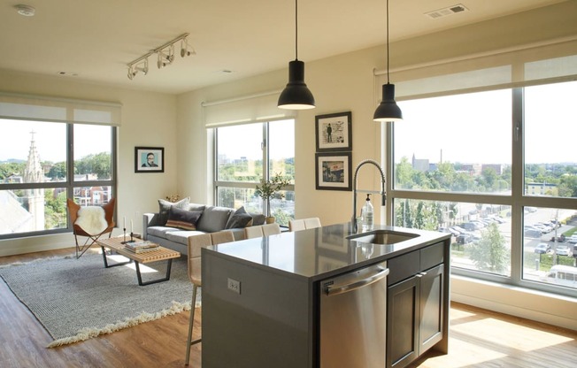 the living room and kitchen of an apartment with a view of the city