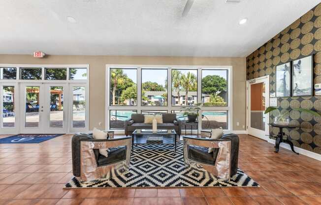 a living room with couches and chairs and a view of a pool