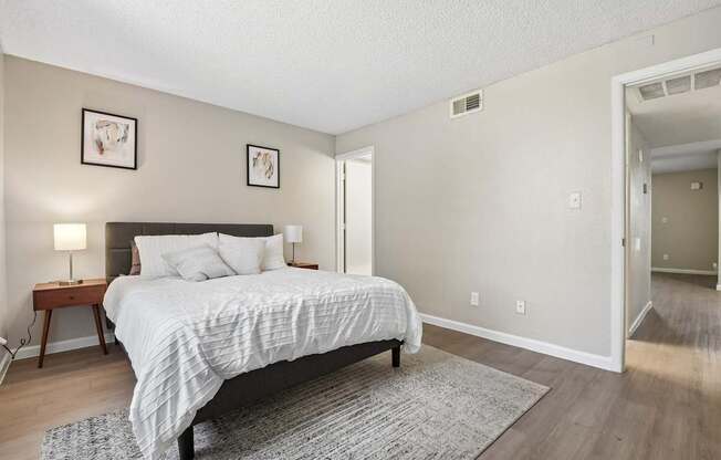 A bedroom with a bed, nightstand, and lamp.