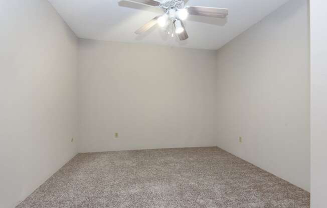 an empty room with white walls and a ceiling fan. Roseville, MN Rosedale Estates