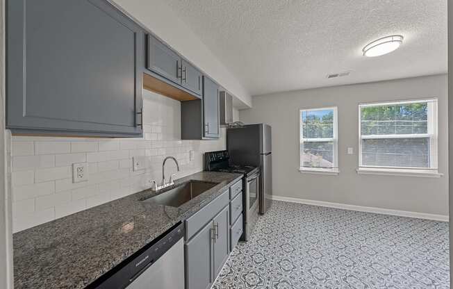 an empty kitchen with granite counter tops and a sink