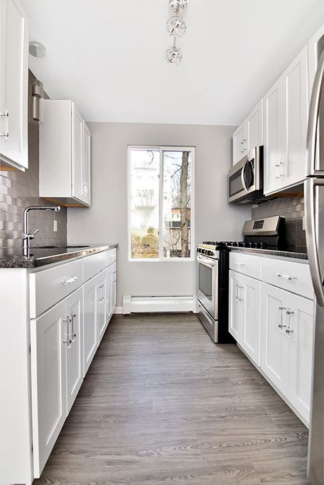 a white kitchen with white cabinets and a window at Springwood Gardens, New Britain