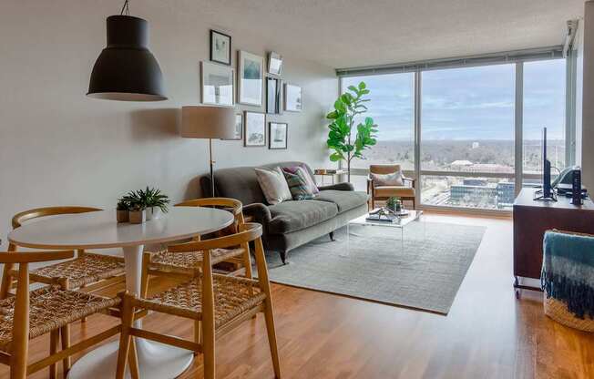 A living room with a couch, a table, and a view of the city.