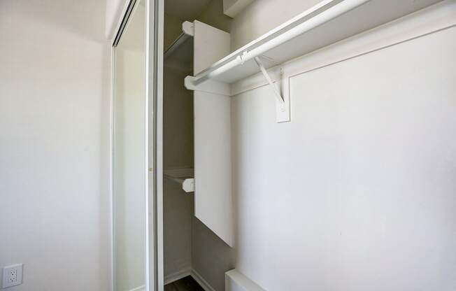 an empty closet with a white wall and a sliding glass door