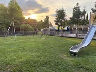 A playground with a slide and a climbing frame.