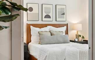 a bedroom with a bed with a white comforter and pillows