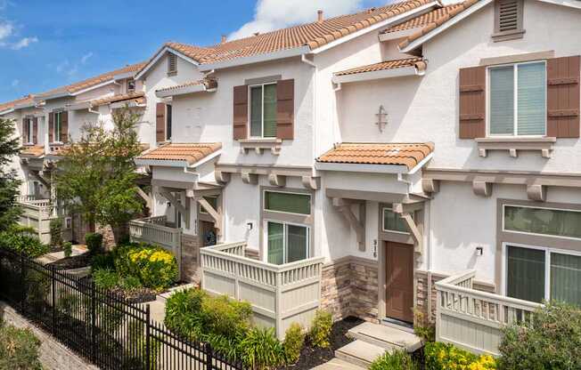 A row of houses with a black fence in front.