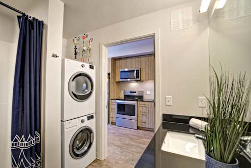 A modern laundry room with a washer and dryer stacked on top of each other.