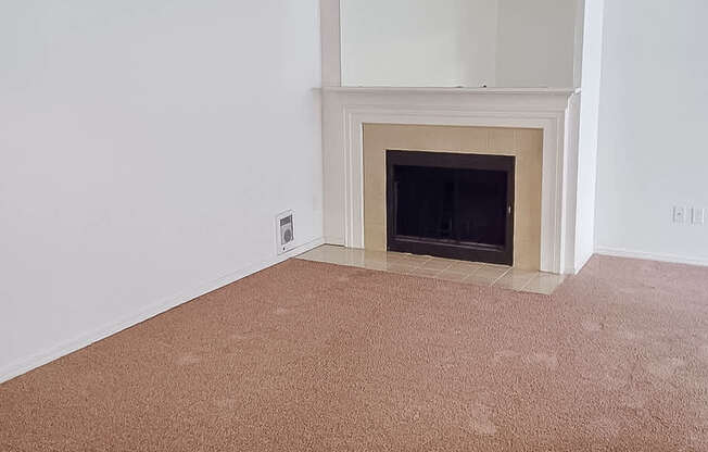 A room with a fireplace and carpeted floor.