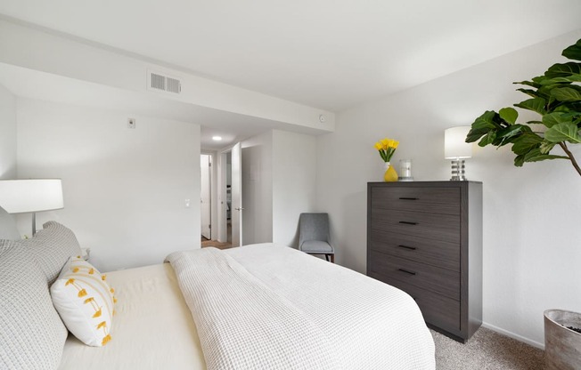 a bedroom with a large white bed and a dresser