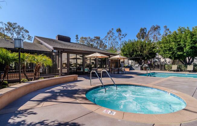 A large outdoor swimming pool with a fountain in the middle.