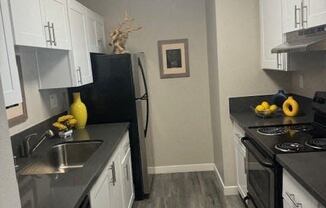 a kitchen with white cabinets and stainless steel appliances