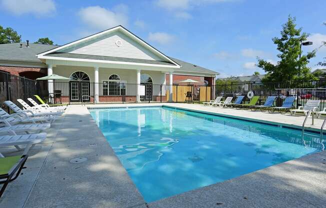 A pool with a white building behind it.