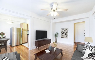 living area with sofa, coffee table, credenza, tv, hardwood floors, ceiling fan and view of kitchen at wakefield apartments in washington dc