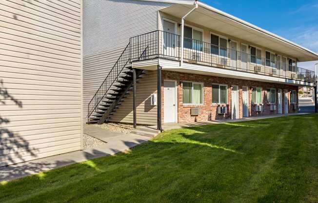 the exterior of a building with a balcony and a lawn