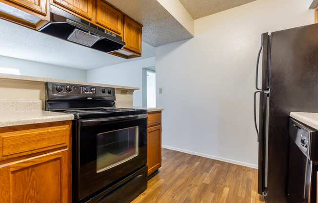 Black appliances and wooden cabinets1 at Coventry Oaks Apartments, Overland Park, KS