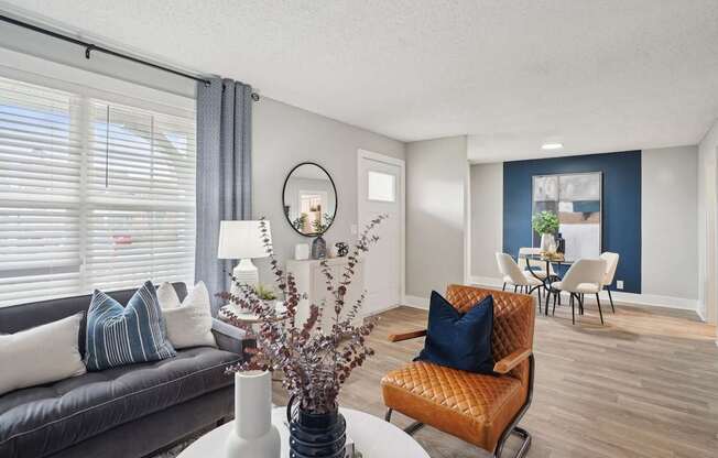 Open-concept living room with natural light and wood-style flooring in a Hendersonville apartment