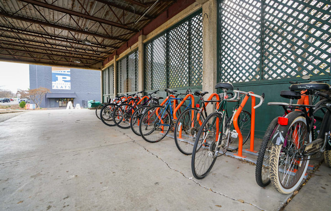 A row of bicycles are parked in a bike rack.