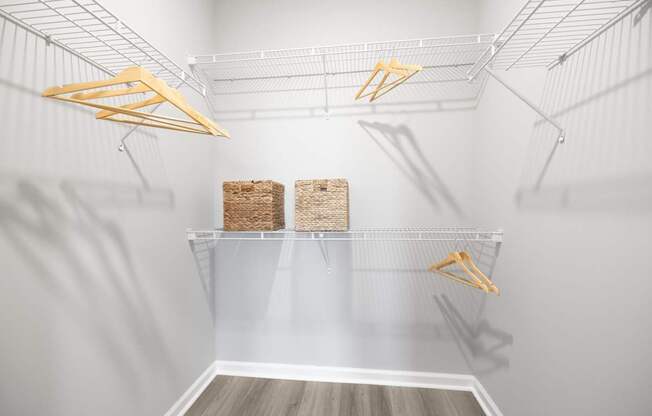 A white pantry with two shelves and hangers at Harbor Pointe Apartments, New Jersey