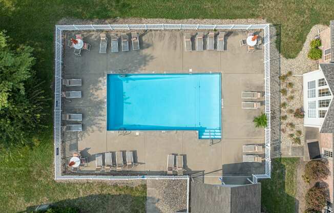 a birds eye view of a swimming pool in the middle of a backyard with