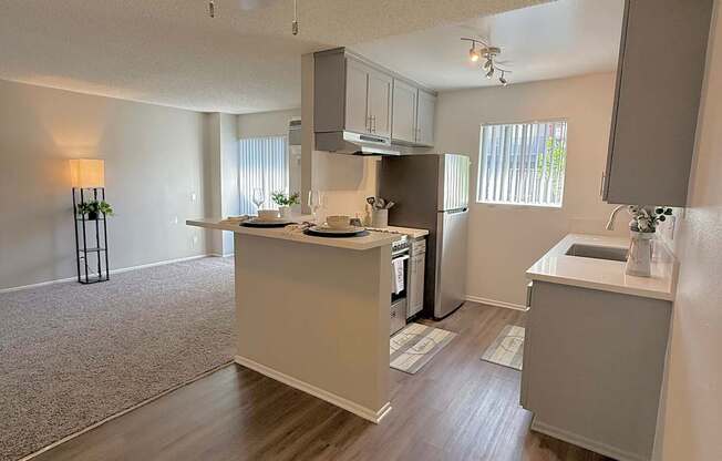 A kitchen with a ceiling fan and a countertop with a sink.