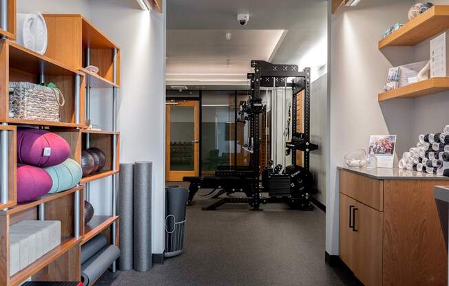 A room with a gym equipment set up and a shelf with various items.