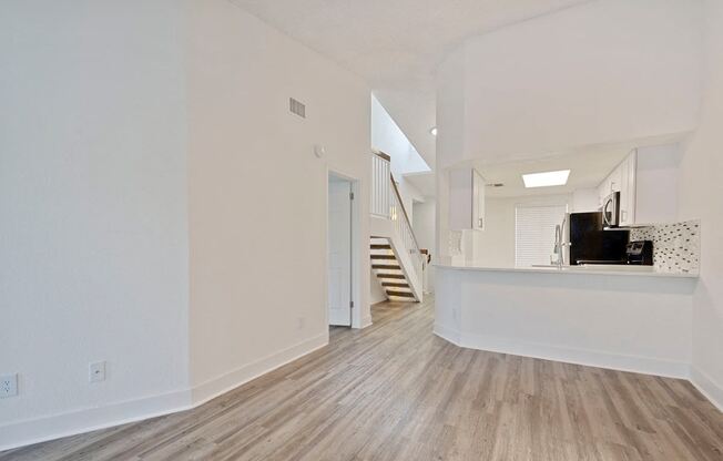 Living room with vinyl flooring looking toward stairway and kitchen