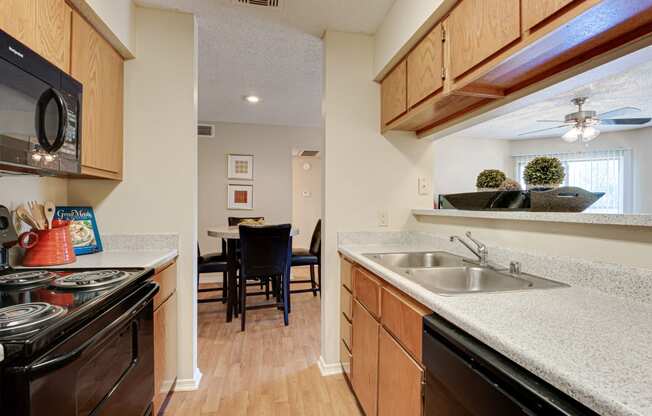 the view of a kitchen with a sink and a stove and a dining room area