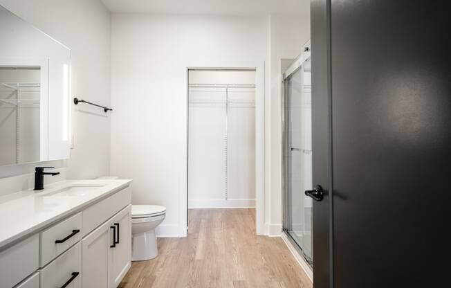 a bathroom with white cabinets and a toilet and a shower