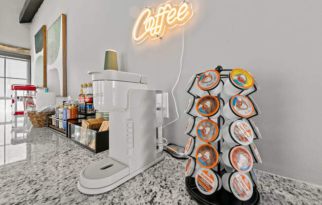 A coffee machine with a neon sign above it.