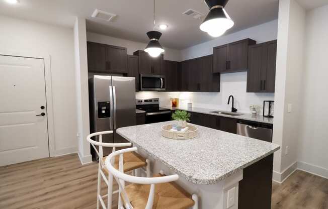 The Crest at South Point 1 Bed Model Apartment Kitchen with Granite Countertops and Stainless Steel Appliances located in McDonough, GA