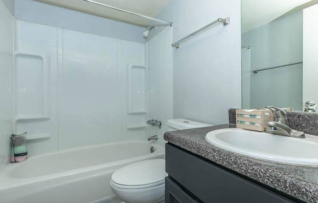 A white toilet sits next to a bathtub in a bathroom.