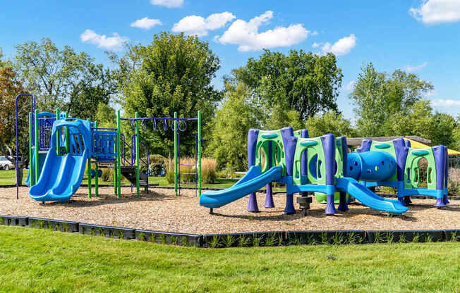 A playground with a blue slide and purple climbing frame.