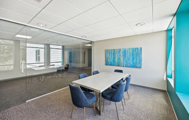 a conference room with a white table and blue chairs