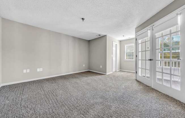 the living room and entryway of a house with white doors