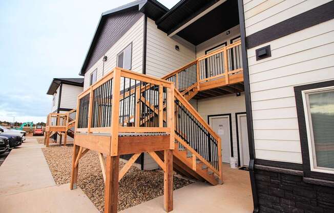 A wooden deck with a railing is in front of a house.