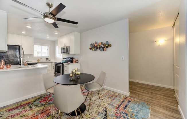 Dining Room with Rug, Hardwood Inspired Floor, Ceiling Fan/Light and Round Black Table