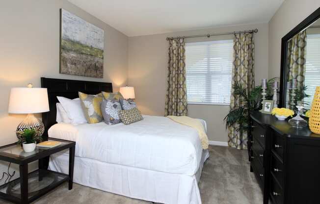 a bedroom with a bed and a dresser and a window