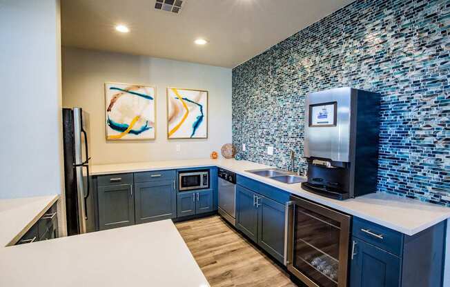 A kitchen with a white counter top and blue cabinets.