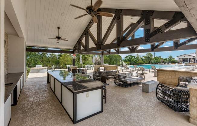 A patio with a table and chairs and a ceiling fan.