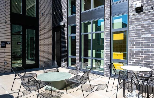 a patio with tables and chairs outside of a building