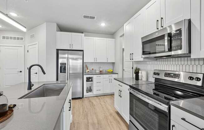 A modern kitchen with stainless steel appliances and white cabinets.