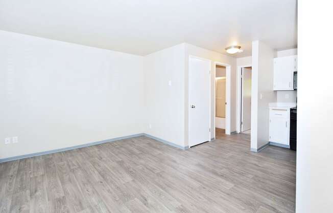 an empty living room with white walls and wood floors